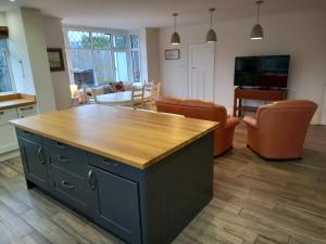 Ben RhyddingGrange Croft的厨房以及带木制台面的客厅。