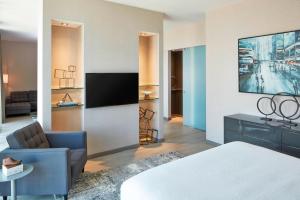 德梅因AC Hotel by Marriott Des Moines East Village的一间酒店客房,配有一张床和一台电视