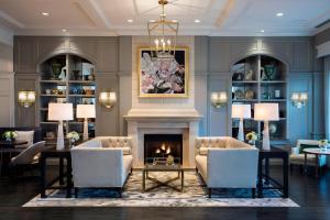 夏洛特夏洛特喜达屋豪华精选度假酒店的客厅设有壁炉、桌子和椅子