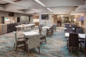 堪萨斯城堪萨斯城乡村俱乐部广场酒店的一间带桌椅的用餐室和一间厨房