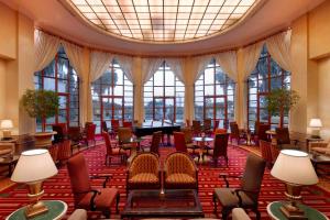 亚的斯亚贝巴Sheraton Addis, a Luxury Collection Hotel, Addis Ababa的大型客房配有桌椅和三角钢琴