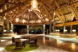 布拉伊新喀里多尼亚喜来登德瓦Spa及高尔夫度假酒店的大型大堂设有木制天花板和桌椅