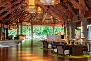 布拉伊新喀里多尼亚喜来登德瓦Spa及高尔夫度假酒店的大堂设有木制天花板和桌椅。
