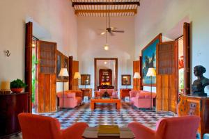 AbaláHacienda Temozon的客厅配有粉红色的椅子和桌子