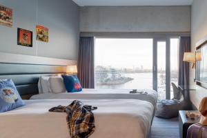 阿姆斯特丹Moxy Amsterdam Houthavens的酒店客房设有两张床和大窗户。
