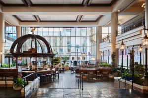新奥尔良新奥尔良喜来登酒店的餐厅设有桌椅和大窗户。
