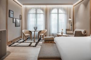 马德里圈大街傲途格精选酒店（仅限成人入住）的酒店客房带一张床、一张桌子和椅子