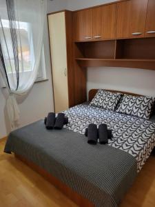 沃德年Apartma DOLORES的一间卧室配有一张带黑色枕头的床和一扇窗户。
