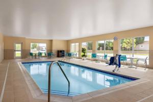 MarionTownePlace Suites Cedar Rapids Marion的酒店的大型游泳池配有桌椅