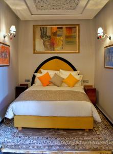 拉巴特Dar Chrifa的一间卧室配有一张带橙色枕头的大床