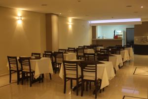 阿帕雷西达Hotel Portobello的一间设有白色桌椅的用餐室