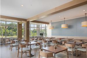 阿米莉亚岛Courtyard Amelia Island的餐厅设有桌椅和窗户。