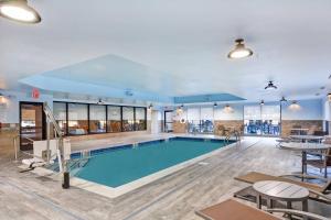 布兰奇堡帕克TownePlace Suites by Marriott Bridgewater Branchburg的一个带桌椅的大房间中的游泳池