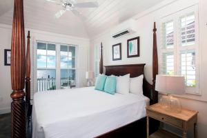 总督港French Leave Resort, Autograph Collection的一间卧室配有带白色床单和蓝色枕头的床。