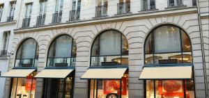 巴黎Chic Apartment on the famous shopping Rue du Faubourg Saint-Honoré street的建筑前方的商店,有窗户