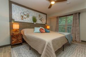 加利纳Gorgeous cabin 3bdrm/3bth, hot tub, fireplace, kid/pet friendly的一间卧室配有一张带两盏灯的床和一扇窗户。