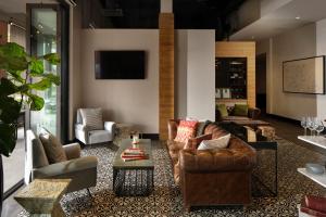 坦帕伊壁鸠鲁酒店，收集签名的带沙发和椅子的客厅以及电视