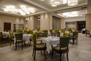 奥韦里Protea Hotel by Marriott Owerri Select的用餐室配有白色的桌子和绿色的椅子
