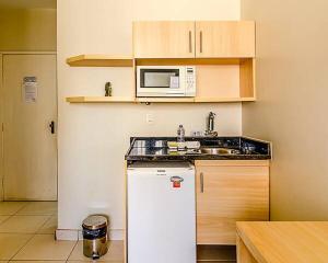 贝洛奥里藏特Villa Neves Residence的厨房配有白色冰箱和微波炉