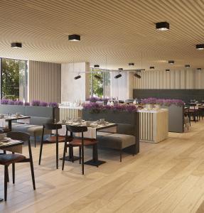 里斯本Hotel Principe Avila的餐厅设有桌椅和紫色鲜花