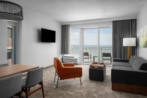 默特尔比奇SpringHill Suites by Marriott Myrtle Beach Oceanfront的客厅配有沙发和桌椅