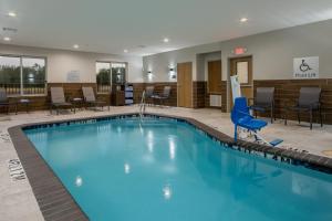 凯蒂Fairfield Inn & Suites Houston Katy的酒店大堂的游泳池,配有桌椅