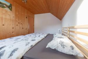 耶塞尼采Apartments Farm House Uric的卧室内的一张床铺,设有木制天花板