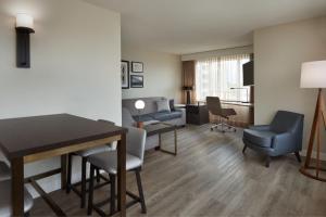 伦敦Residence Inn by Marriott London Canada的一间客厅,客厅内配有桌椅