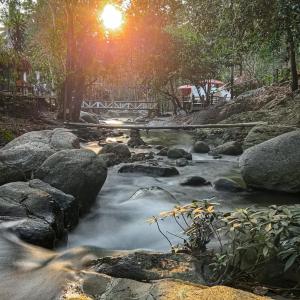 Ban Pok Naiเดอะริเวอร์ แม่กำปอง The River Maekampong Chiang Mai的一条河,河底下有岩石和太阳