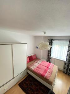 山麓布伦cozy apartment close to vienna的一间卧室配有一张带粉色毯子的床