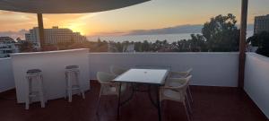 阿罗纳Chill out Apartment Tenerife的阳台上的桌椅享有日落美景