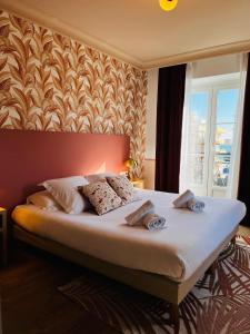 芒通伦敦酒店的一间卧室设有一张大床和墙壁