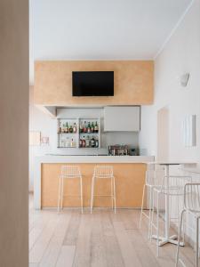 马里纳-迪-皮特拉桑塔米尔顿酒店 的厨房设有带凳子的酒吧和一台电视机。