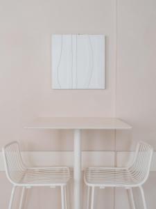 马里纳-迪-皮特拉桑塔米尔顿酒店 的一张带两把椅子的白色桌子和一张照片