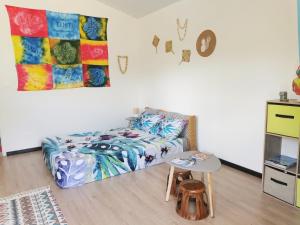 PaeaTAHITI - Orofero Lodge的一间卧室配有一张床和一张桌子
