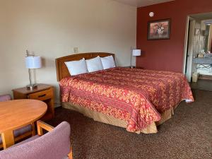 圣安东尼奥Travel Inn lackland Sea World的酒店客房配有一张床铺和一张桌子。
