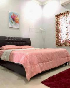 万挠Kundang Villa @ Tasik Biru - 3 Bedrooms Bungalow的一间卧室配有一张带粉色毯子的床