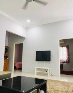 万挠Kundang Villa @ Tasik Biru - 3 Bedrooms Bungalow的客厅配有白色墙壁上的平面电视。