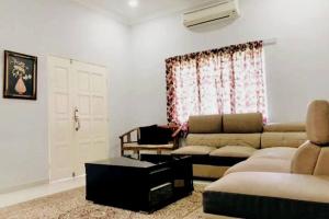 万挠Kundang Villa @ Tasik Biru - 3 Bedrooms Bungalow的带沙发和窗户的客厅