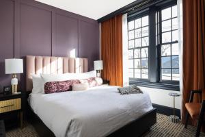 朴茨茅斯Hotel Thaxter的一间卧室设有一张大床和两个窗户。