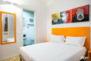 斯培西亚Lia Art Hotel的卧室配有白色的床和镜子