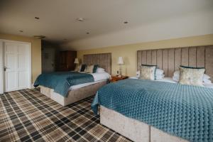 基尔基Bay View Hotel的一间卧室配有两张带蓝色棉被的床