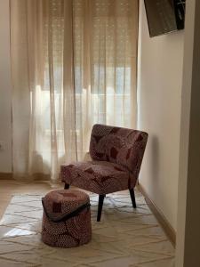 纳维亚Pensión Cantabrico的窗户房间里一张椅子和一张凳子