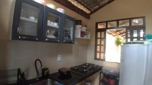 瓜拉米兰加Belaninha的厨房配有炉灶、冰箱和窗户。
