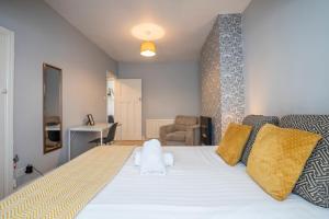 Lemington3 Bed Flat-Close to City Centre的卧室配有一张带黄色枕头的大型白色床。