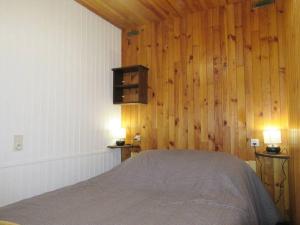 普雷芒翁Au Coeur du village de Prémanon的卧室配有木墙内的一张床