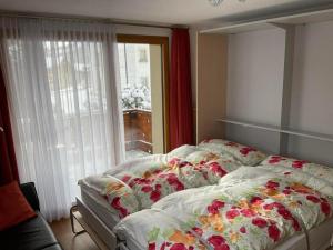 切勒里纳Aivla的一间卧室配有一张带花卉图案的床单和窗户