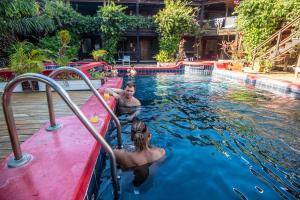 乌蒂拉Mango Inn Resort的游泳池里的男人和女人