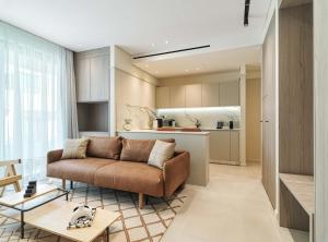 拉纳卡LIV Mackenzie Beach Suites Larnaca ADULTS ONLY的带沙发的客厅和厨房