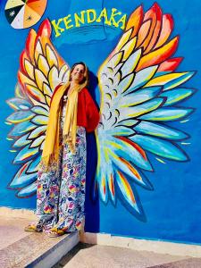 阿斯旺Kendaka Nubian House的站在墙上的女人,上面涂着蝴蝶